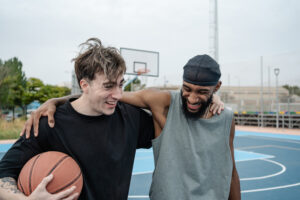 Two basketball players smiling after playing ball